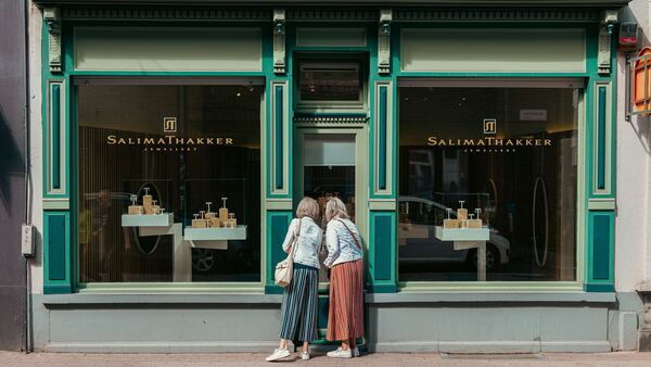 Two people in front of a shop window 