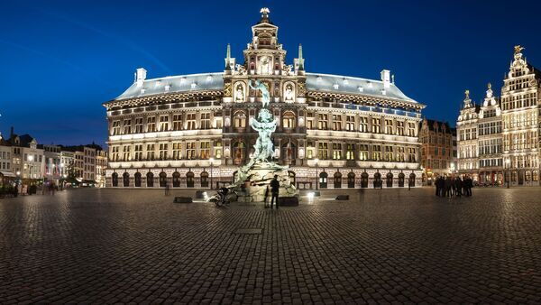 View of a beautifully lit market square with town hall and Brabo fountain.