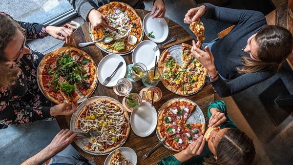 Freundinnen teilen sich Pizzen in der Pizzeria Otomat