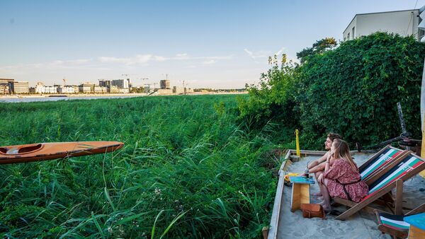 Couple enjoy the skyline on Antwerp at summer bar Kamyon