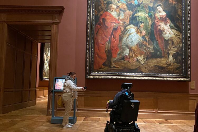 Simon und Begleiter in einem Museumsraum beim Anhören eines Audioclips. KMSKA mit Rollstuhl