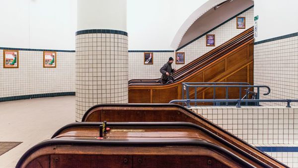Escaliers mécaniques en bois dans un hall circulaire d'un bâtiment tunnel moderniste