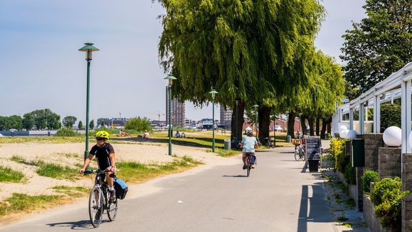 A helmeted cyclist rides past St Anne's beach.
