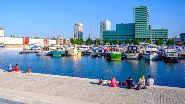 People enjoying the boats in the Kempisch dock by the water.