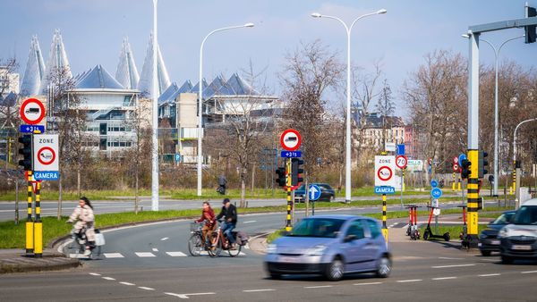 A picture of a busy intersection where traffic signs indicate that a low-emission zone is in effect. 