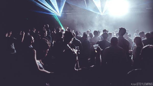 Público de fiesta en un club con luces de discoteca