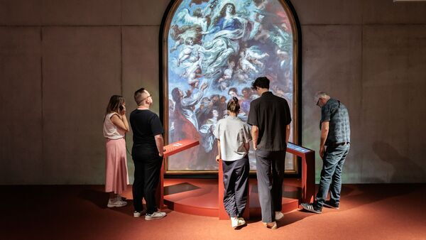 Mensen kijken naar een kunstwerk in het Rubenshuis tijdens de Rubens Experience