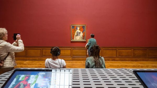 Quelques enfants et femmes regardent le portrait "Madone" de Fouquet dans une salle du Musée royal des Beaux-Arts.