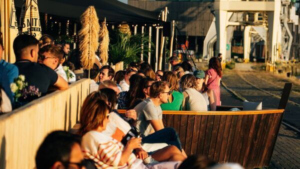 Gente disfrutando del sol, una copa y buena compañía en la terraza de Gazon Antwerp