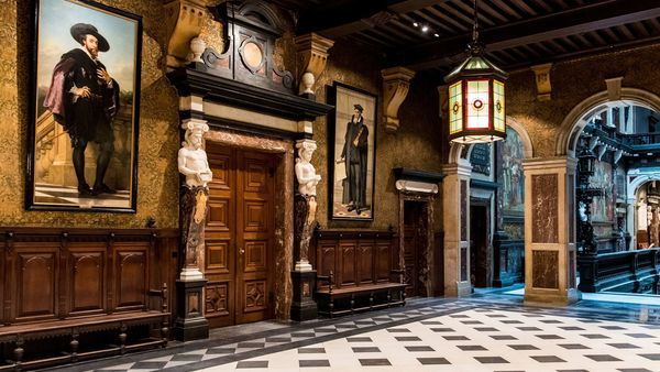 Ayuntamiento, sala en el piso "het Schoon Verdiep" con tallas y estatuas decorando la puerta. En la pared cuelgan cuadros antiguos.