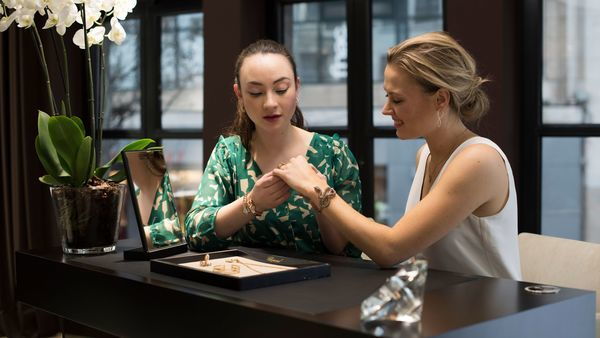 Two women in a jewellery shop look at jewellery and rings.