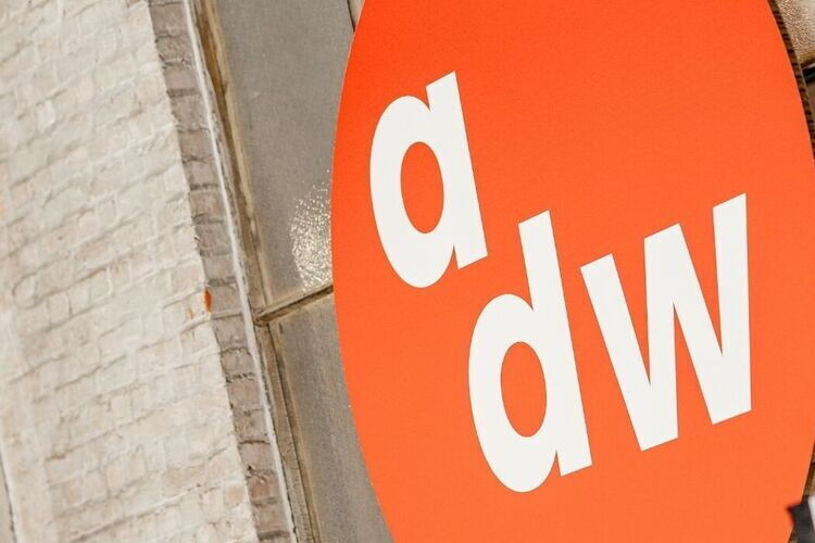 Het logo van ADW hangt groot op een grijze muur tijdens Antwerp Design Week.