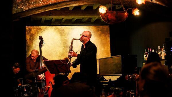Drie muzikanten spelen een optreden in een café.