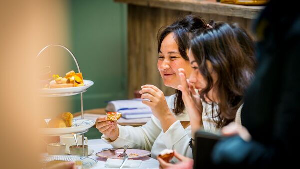 Twee dames genieten met hun mannen van zoet lekkernijen in Salon de thé Claude