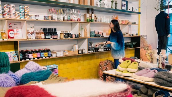Mädchen betrachtet die Regale mit Lebensmitteln und Accessoires von Curated by EDO