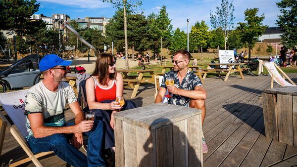 Park Spoor Noord, people enjoy a drink in beach chairs. 