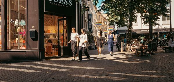 Wilde Zee: two women walk past Guess store