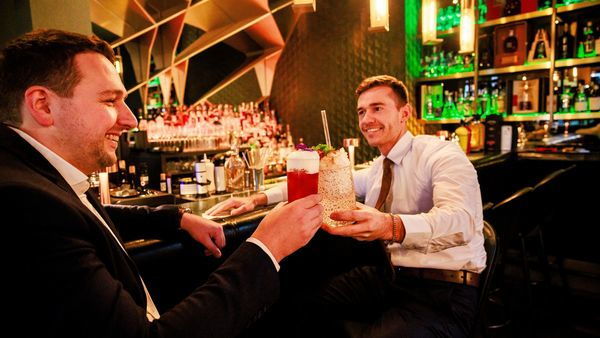 Dos hombres con cócteles en la mano 