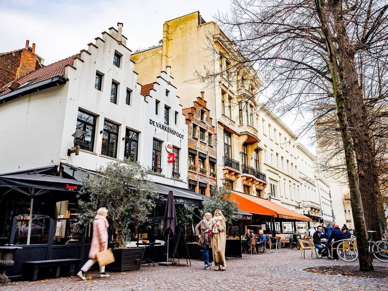 Mensen wandelen en genieten van een drankje op Graanmarkt tijdens de herfst