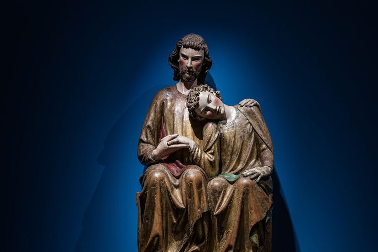 Een groot, houten sculptuur van Christus en Johannes, die zijn hoofd op Jezus' schouder laat rusten.