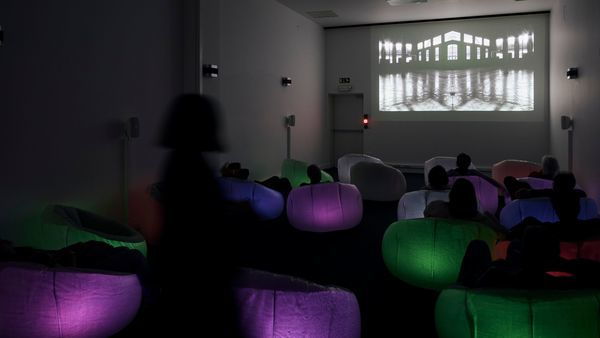 M HKA, bezoekers kijken naar een film in een verduisterde ruimte van het museum