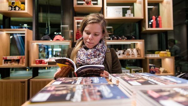 Klant bekijkt promotiemateriaal van Antwerpen in het bezoekerscentrum Centraal Station