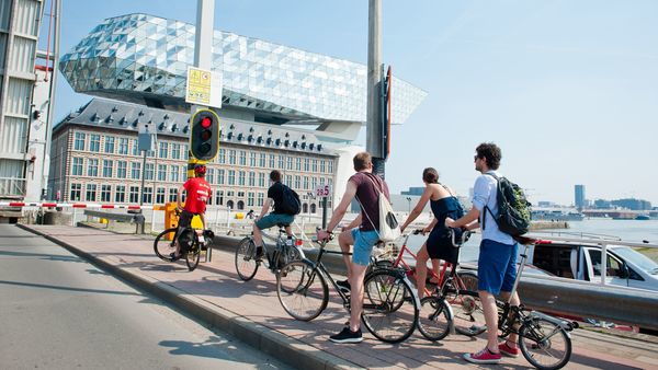 Vrienden op de fiets aan het Havenhuis van Antwerpen
