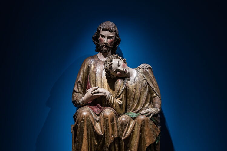 Une grande sculpture en bois représentant le Christ et Jean, qui repose sa tête sur l'épaule de Jésus.