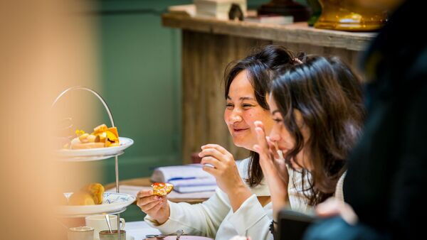 Deux dames dégustent des friandises avec leurs maris dans le Salon de thé Claude
