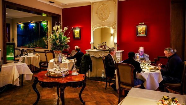 Deux tables dégustant de bons plats dans l'intérieur classique et chaleureux du restaurant Loncin