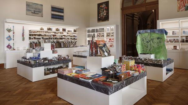 La boutique du KMSKA où sont exposés divers articles à vendre, tels que des livres et des cartes postales.