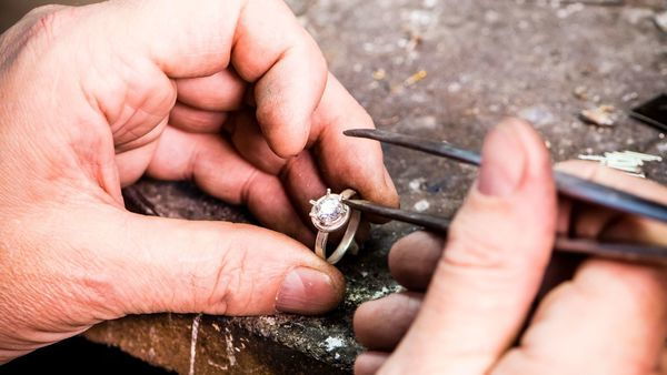 Hands place a diamond in ring | Nico Taeymans