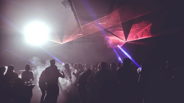 Público de fiesta en un club con luces de discoteca