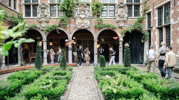 Visitors walk in the courtyard garden of Plantin-Moretus museum.