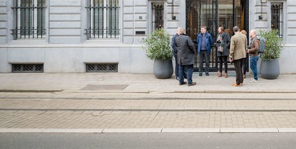 Eine Gruppe von Menschen am Eingang eines Hotels.
