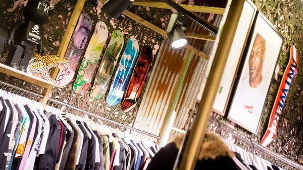 Kleiderständer bei Vier, Skateboards und Poster an der Wand