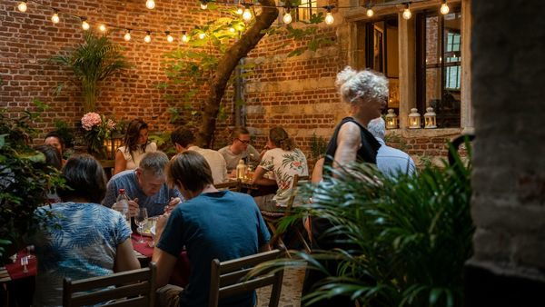 People having dinner in the evening on the cosy terrace of 't Hofke with atmospheric lights