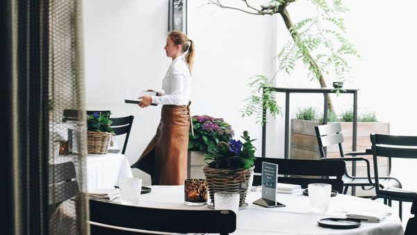 Een hotelmedewerker dient op in het restaurant van een hotel