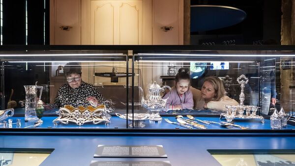 3 generations look at the jewellery displayed in the museum.