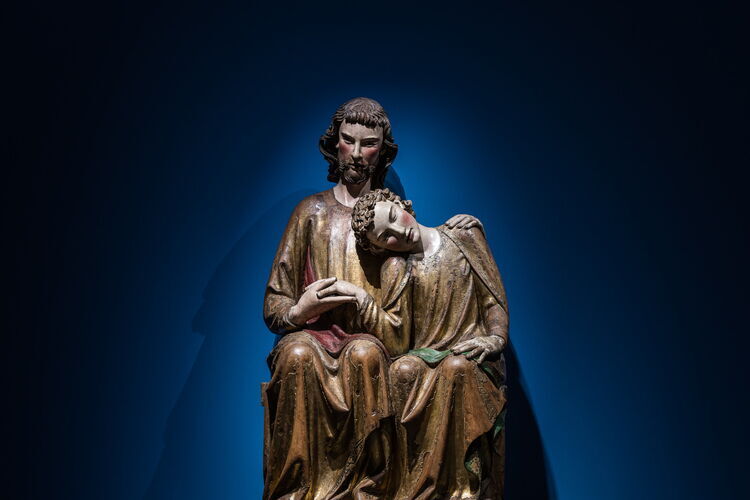 Une grande sculpture en bois représentant le Christ et Jean, qui repose sa tête sur l'épaule de Jésus.