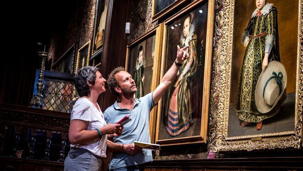 Ein Paar betrachtet Gemälde im Mayer Van den Bergh Museum. 
