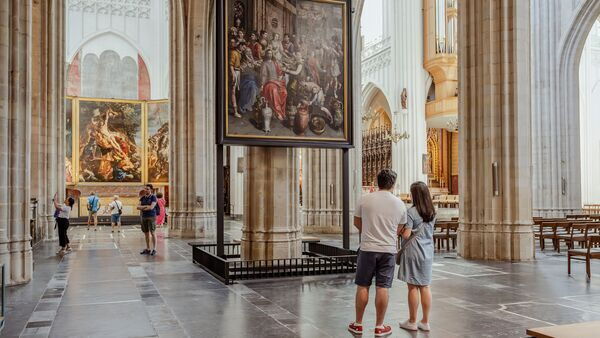 Bezoekers staan stil bij een kunstwerk in de kathedraal.