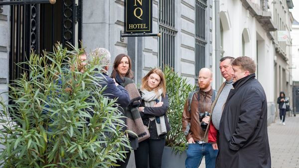 A group of people at the front of a hotel