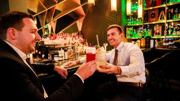 Two men holding cocktails
