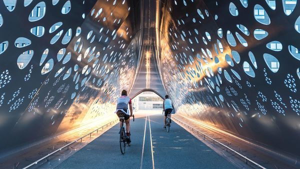 Two cyclists cycle through the Park Bridge.