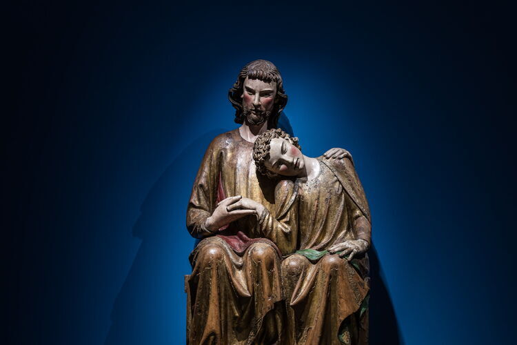 Eine große Holzskulptur von Christus und Johannes, der seinen Kopf auf Jesu Schulter ruht.