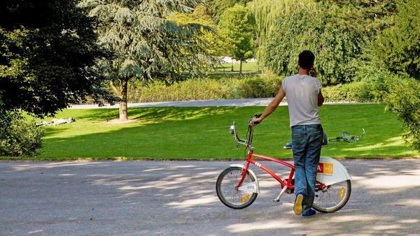 Man stands with a Velo in City Park.