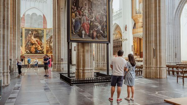 Des visiteurs s'arrêtent devant une œuvre d'art de la cathédrale.