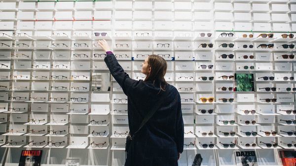 Een dame kiest een bril in een brillenwinkel