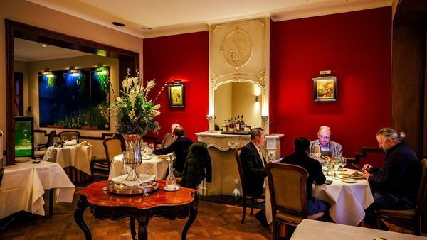 Twee tafeltjes genieten van lekker eten in het klassiek en gezellig interieur van restaurant Loncin